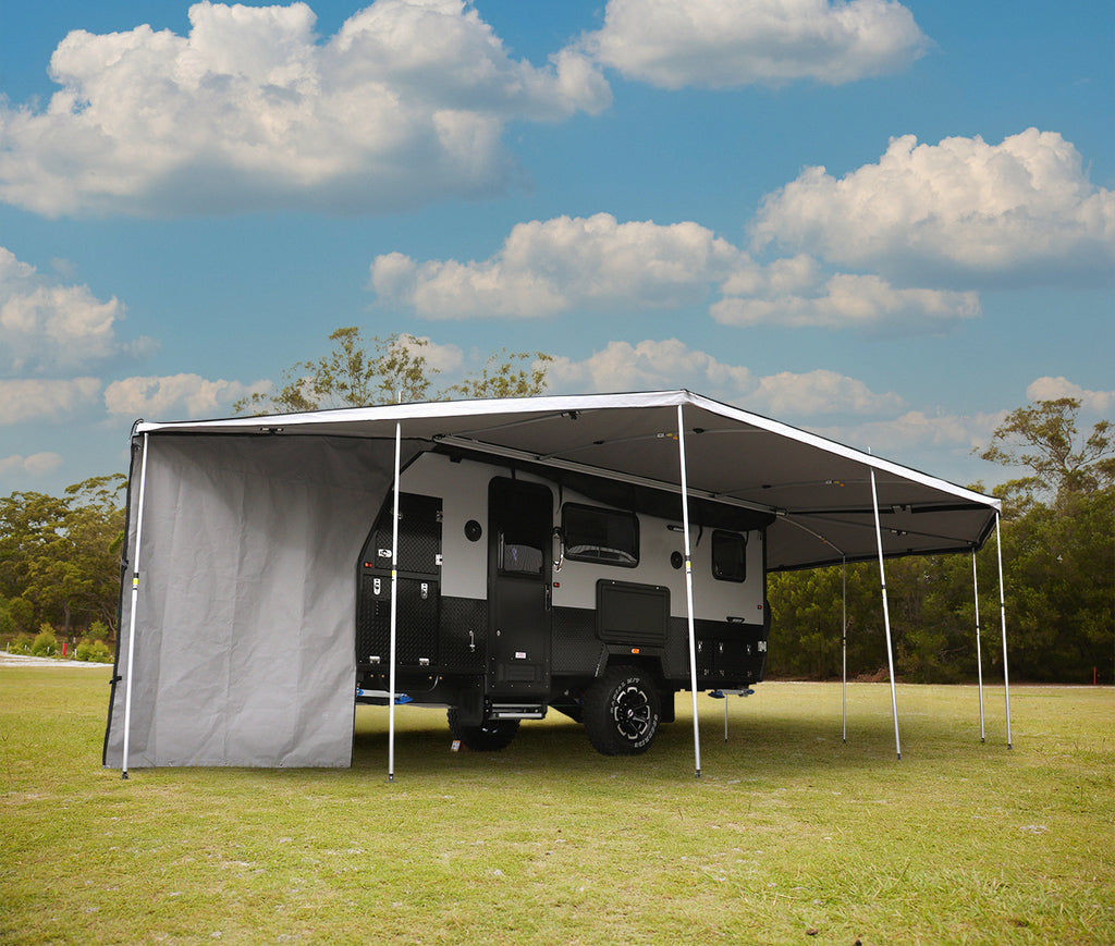 Supa Wing Awning Hybrid Camper Pack - Supa Wing awning with infill set up on a black and white hybrid camper/caravan. Set on grass with trees in the background. 